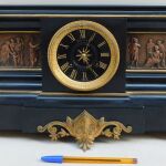 Ρολόι επιτραπέζιο μαρμάρινο με ανάγλυφες χάλκινες παραστάσεις, περίπου 130 ετών.