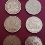 7 παλαιά, ελληνικά συλλεκτικά νομίσματα, των εκατό δραχμών με τον Μέγα Αλέξανδρο και τον Ήλιο της Βεργίνας και από το παγκόσμιο πρωτάθλημα στίβου και ελληνορωμαϊκής  πάλης.